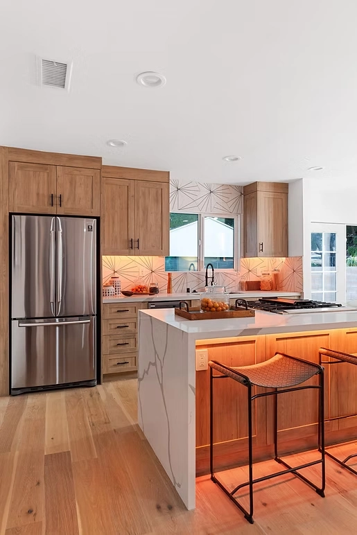 Kitchen remodel with under-cabinet lighting, wooden cabinets, and a sleek countertop design.