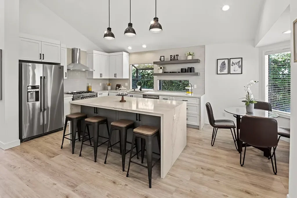 Elegant kitchen remodel with a large island, pendant lighting, and open shelving.
