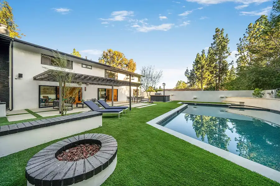 Modern home with swimming pool, artificial grass, and outdoor seating area. Nobel Builders
