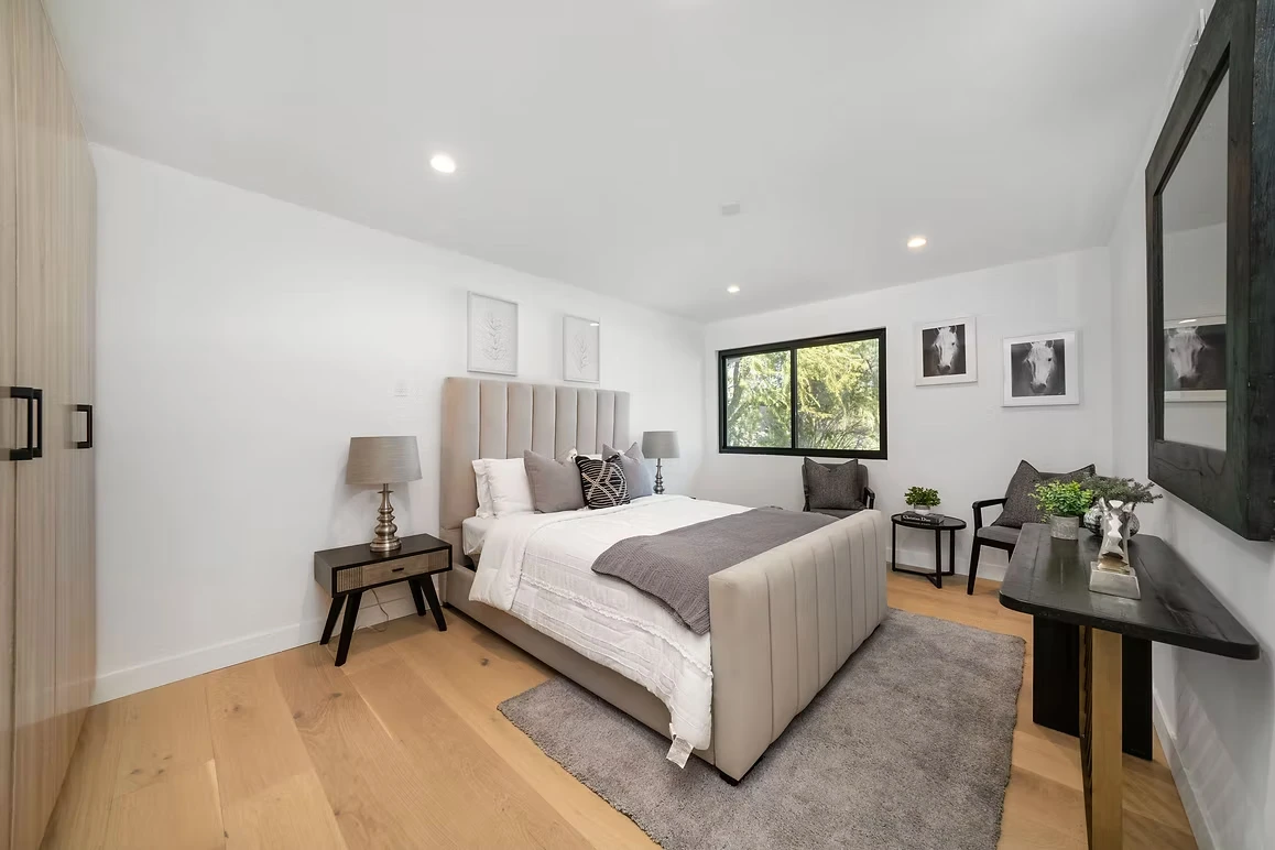 Bright and modern bedroom with neutral decor, natural light, and sleek furniture.