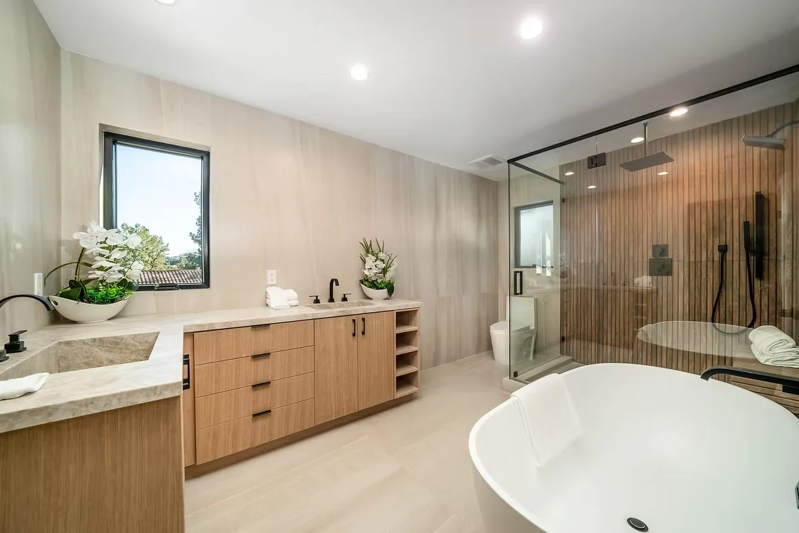Elegant bathroom with a freestanding tub, modern shower, and wood vanity.