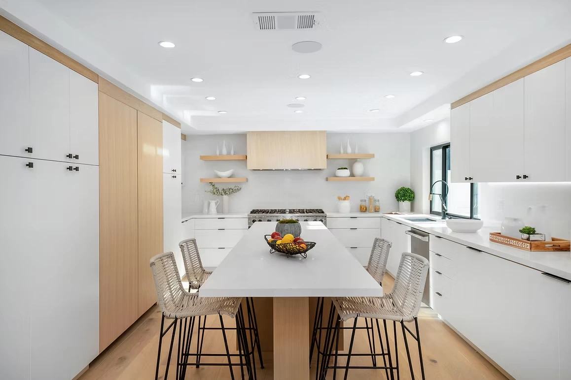 Contemporary kitchen with white cabinetry, open shelving, and a spacious island.