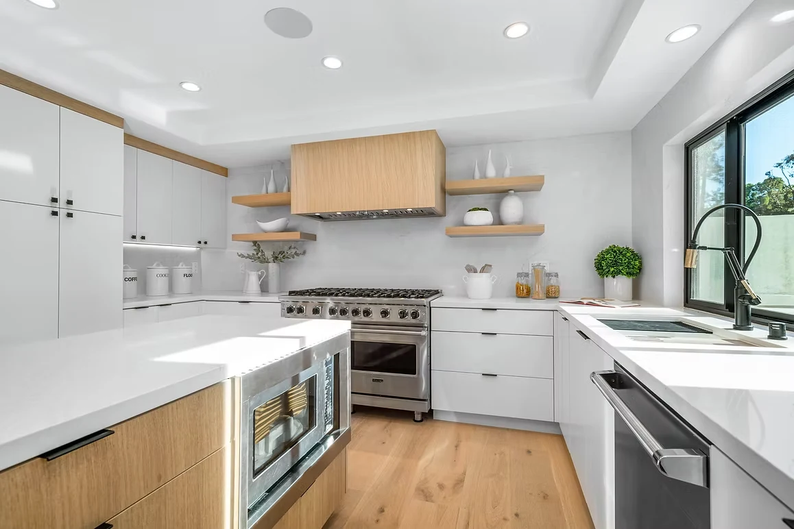 Modern kitchen remodel with white and wood cabinetry, stainless steel appliances, and sleek design.