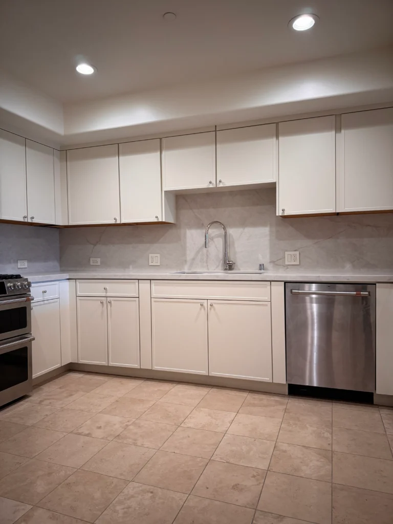 A kitchen featuring newly installed white cabinets, light countertops, and a stainless steel dishwasher.